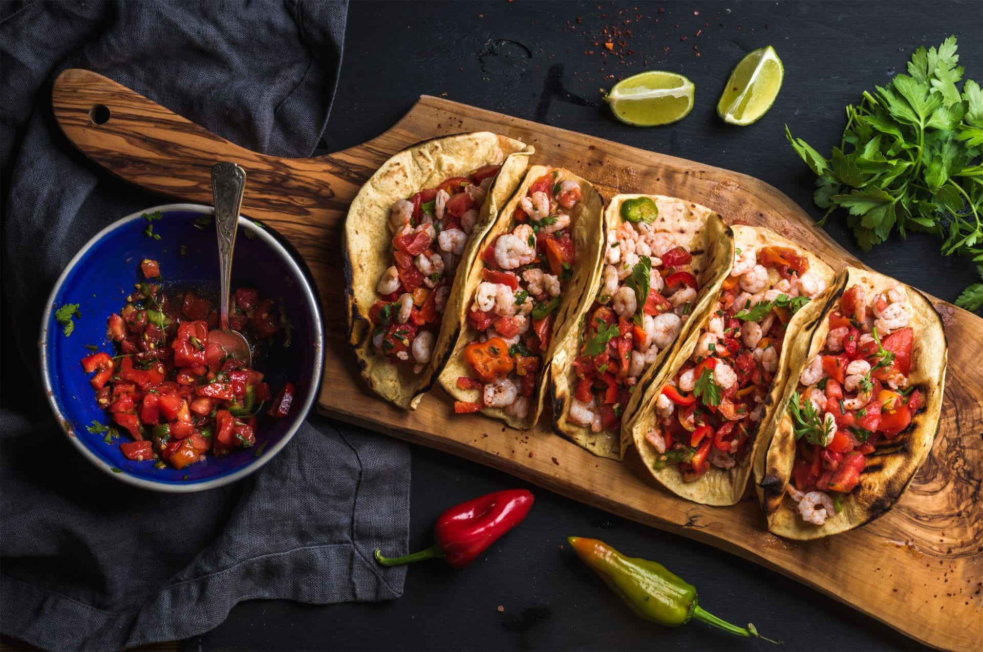 A wooden board of street tacos with fresh salsa, made by Authentic Street Taco